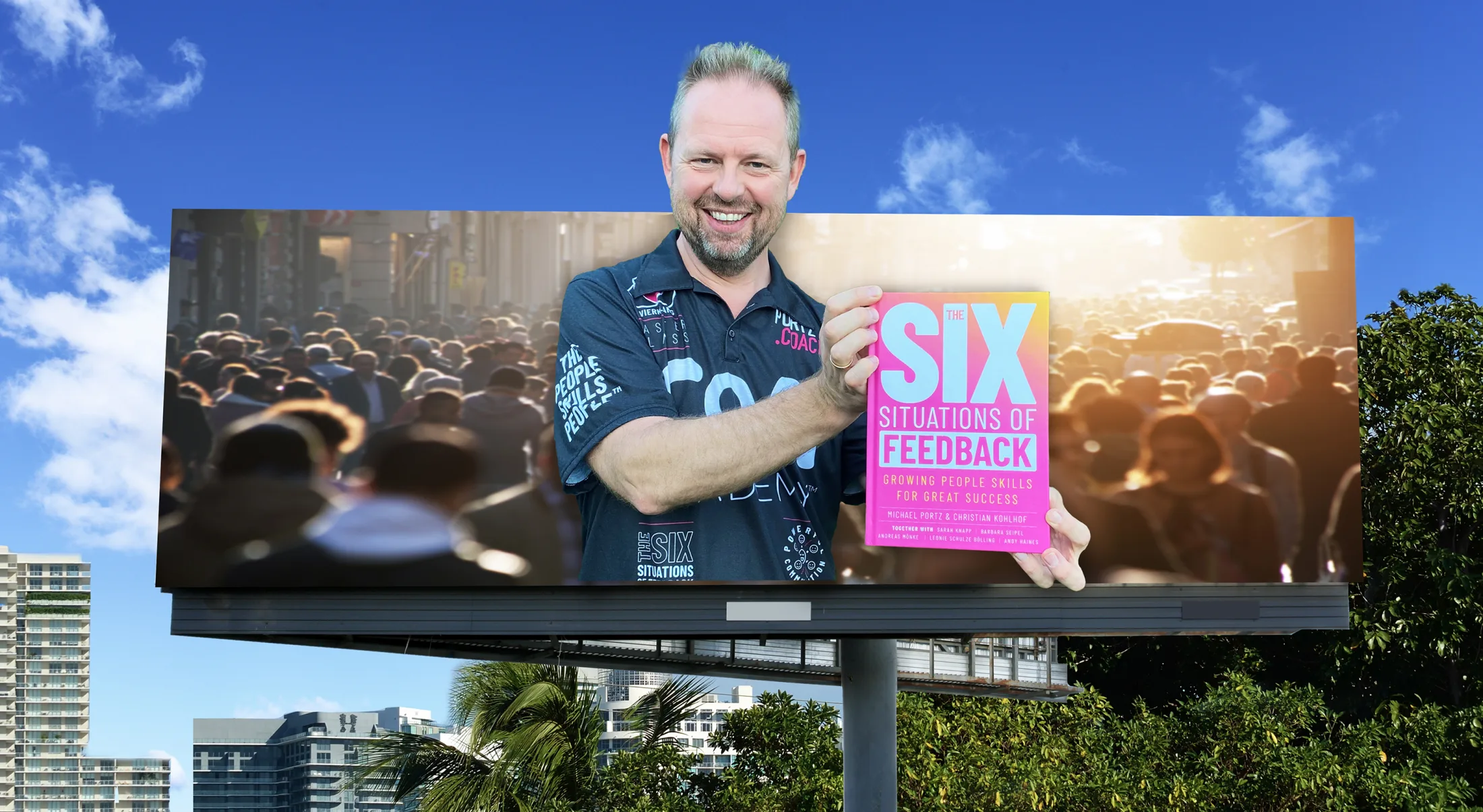 Michael Portz holding The Six Situations of Feedback in front of a billboard of the book